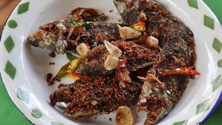 Bekasam goreng dengan taburan bawang putih dan cabai di piring enamel